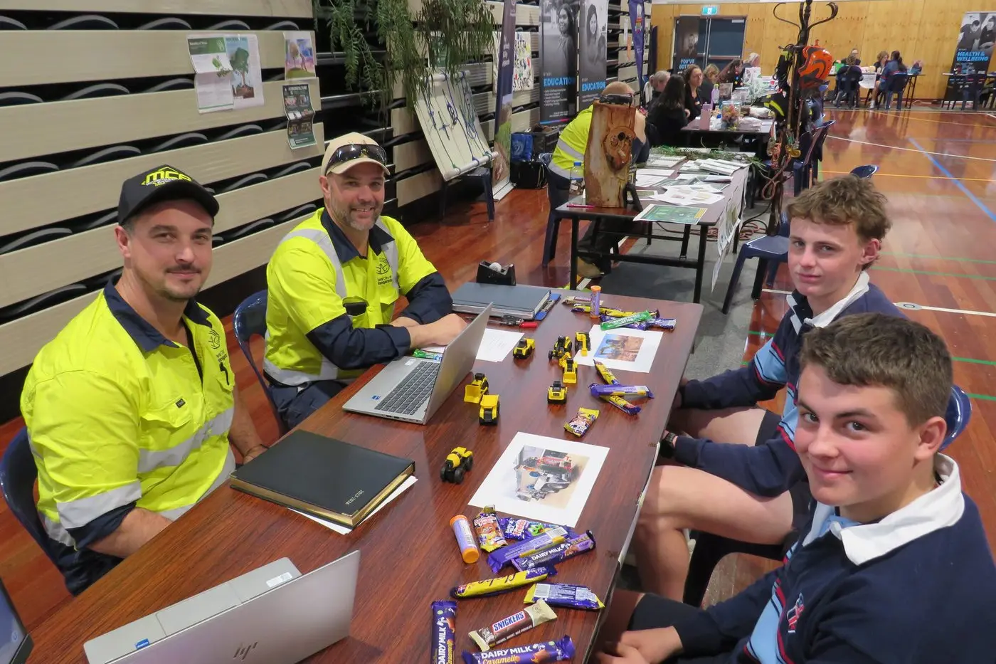 Cohan Love and Luke Weber chat to Cathedral College students Henry Holm (front) and Connor Ormond at the road maintenance stall.\\n