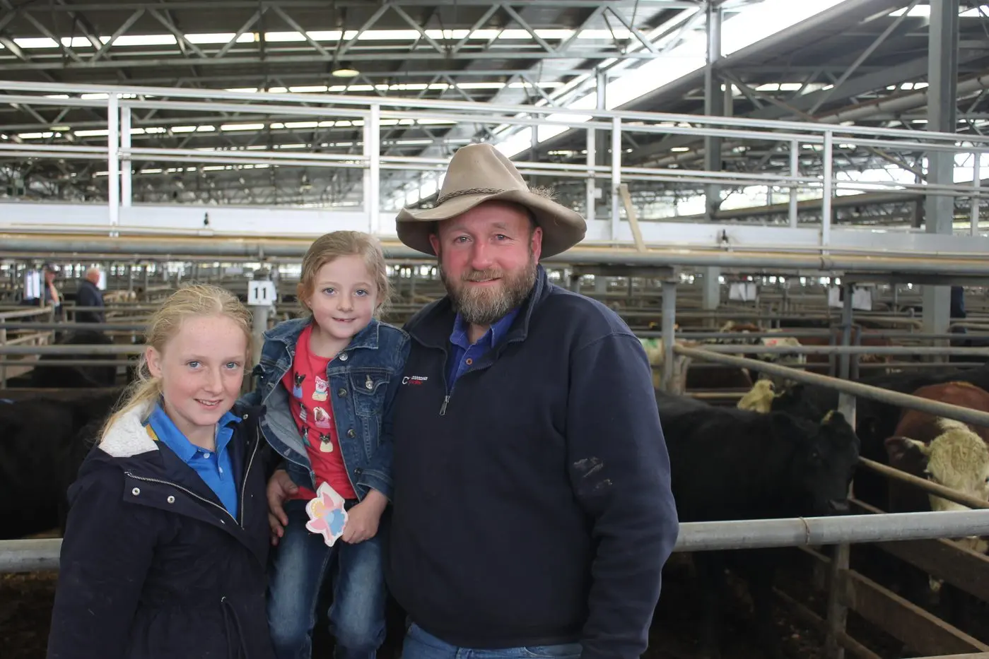 CHEERY TIMES AHEAD: Corcoran Parker cattle agent Daniel Craddock brought along daughters Tara and Felicity to the monthly store cattle sale on Friday morning, as kids made the most of their last days of school holidays. PHOTO: Bailey Zimmermann