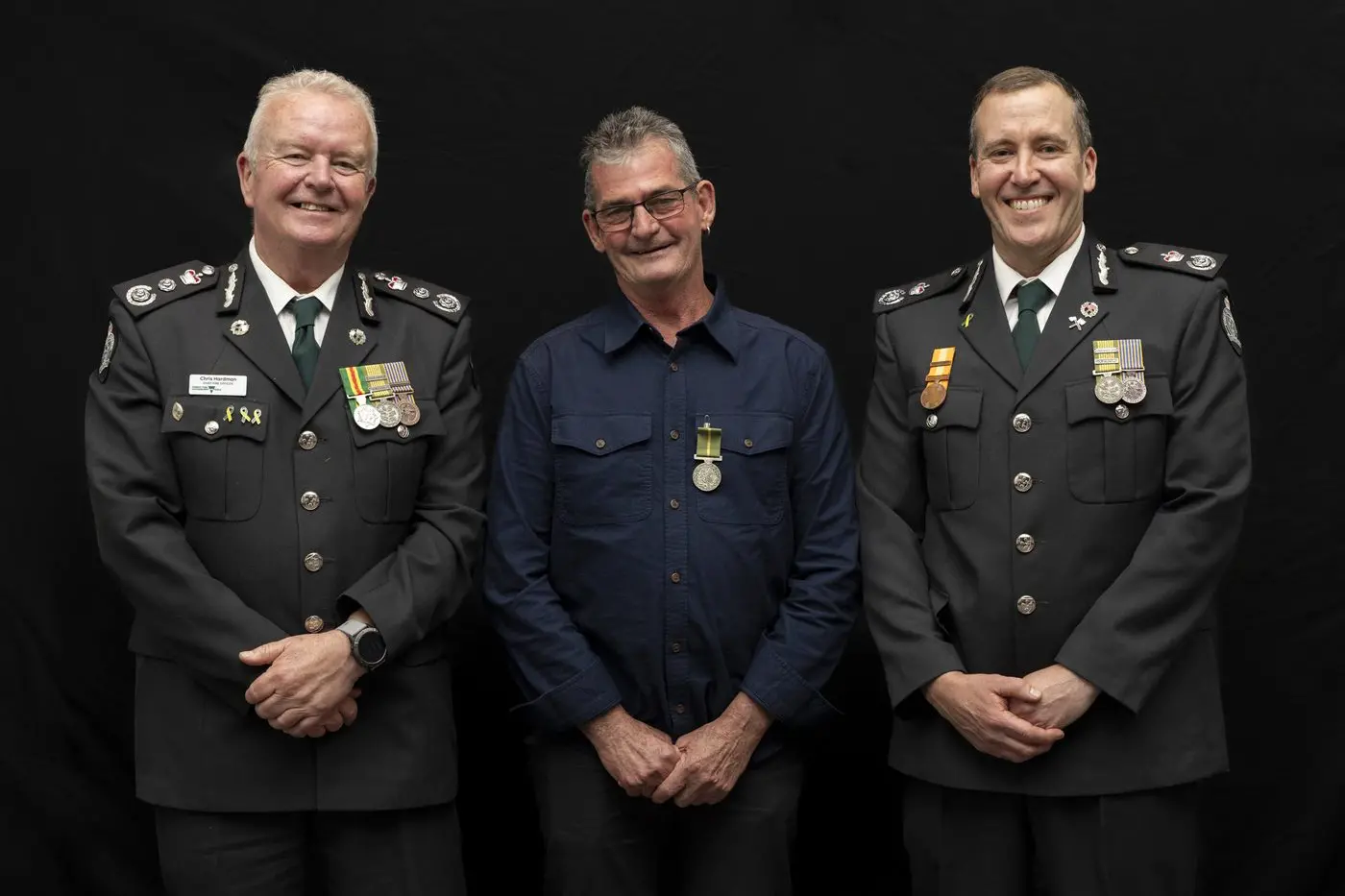 RECOGNITION: FFMVic chief fire officer Chris Hardman (left) and  FFMVic Hume deputy chief fire officer Aaron Kennedy (right) congratulated veteran Ovens-based forest fighter Tracy Culhane on his medal for overseas service.