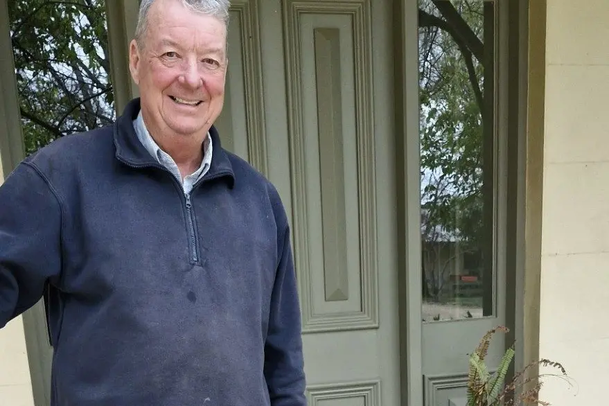 Ross Carrington with his faithful kelpie Dusty on the verandah of his rebuildt homestead.\\n