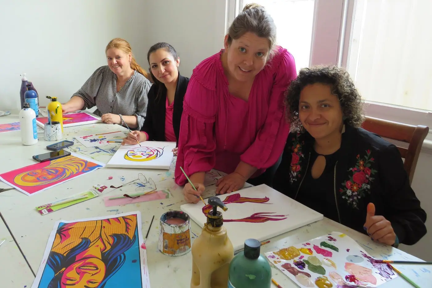 COLOURFUL COLLECTION: Pangerang Community Hub executive officer Tennille Hall, Faryal Khan from the North East Multicultural Association (NEMA), Samantha Badrock from Wangaratta Art School, and Antoinette Vicentello from NEMA prepare their pieces for the Pangerang art exhibition. PHOTO: Simone Kerwin\\n