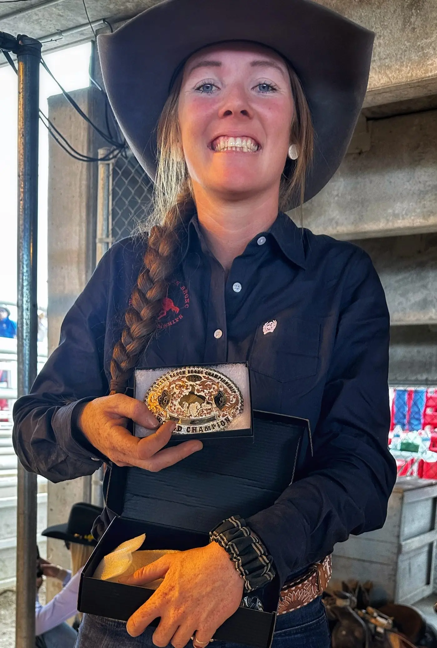 CHAMPION: The smile on Tup Forge\\u2019s face says it all as she shows off the gold buckle for winning the 2025 world women\\u2019s ranch bronc championship at Cheyenne Frontier Days in Wyoming, US. PHOTOS: Supplied.